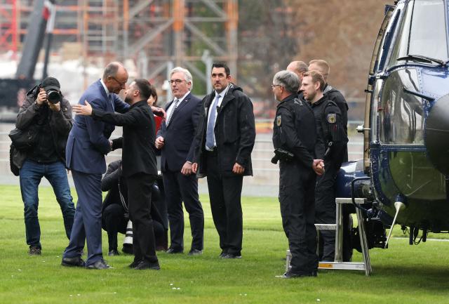 German Chancellor Friedrich Merz hugs Ukrainian President Volodymyr Zelensky upon his arrival with a helicopter in the backyard of the Chancellery in Berlin on April 14, 2026 prior to German-Ukrainian government consultations. The meeting comes as US-initiated peace talks between Russia and Ukraine have stalled, with Kyiv baulking at the idea it could cede territory to Russia. (Photo by Odd ANDERSEN / AFP)