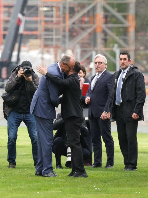 German Chancellor Friedrich Merz hugs Ukrainian President Volodymyr Zelensky upon his arrival with a helicopter in the backyard of the Chancellery in Berlin on April 14, 2026 prior to German-Ukrainian government consultations. The meeting comes as US-initiated peace talks between Russia and Ukraine have stalled, with Kyiv baulking at the idea it could cede territory to Russia. (Photo by Odd ANDERSEN / AFP)