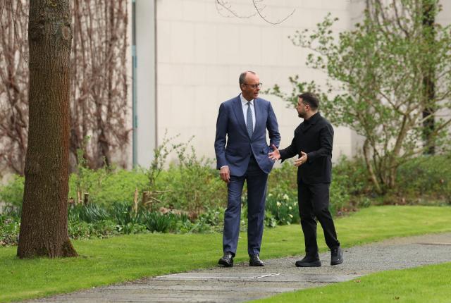 German Chancellor Friedrich Merz and Ukrainian President Volodymyr Zelensky walk in the garden in the backyard of the Chancellery in Berlin on April 14, 2026 prior to German-Ukrainian government consultations. The meeting comes as US-initiated peace talks between Russia and Ukraine have stalled, with Kyiv baulking at the idea it could cede territory to Russia. (Photo by Odd ANDERSEN / AFP)