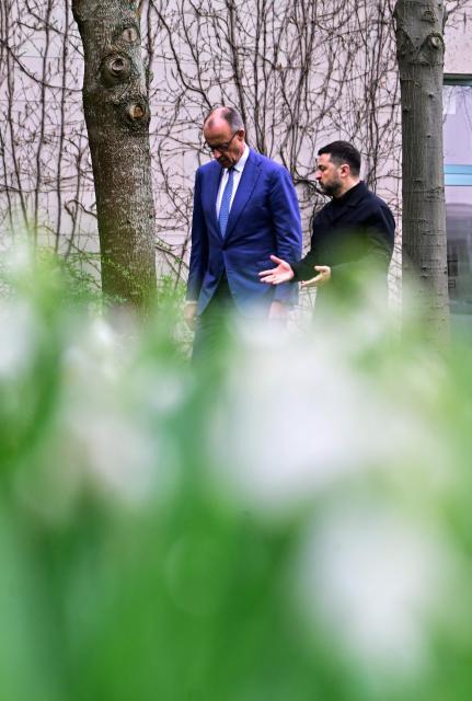 German Chancellor Friedrich Merz and Ukrainian President Volodymyr Zelensky walk in the garden in the backyard of the Chancellery in Berlin on April 14, 2026 prior to German-Ukrainian government consultations. The meeting comes as US-initiated peace talks between Russia and Ukraine have stalled, with Kyiv baulking at the idea it could cede territory to Russia. (Photo by Tobias SCHWARZ / AFP)
