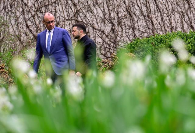 German Chancellor Friedrich Merz and Ukrainian President Volodymyr Zelensky walk in the garden in the backyard of the Chancellery in Berlin on April 14, 2026 prior to German-Ukrainian government consultations. The meeting comes as US-initiated peace talks between Russia and Ukraine have stalled, with Kyiv baulking at the idea it could cede territory to Russia. (Photo by Tobias SCHWARZ / AFP)