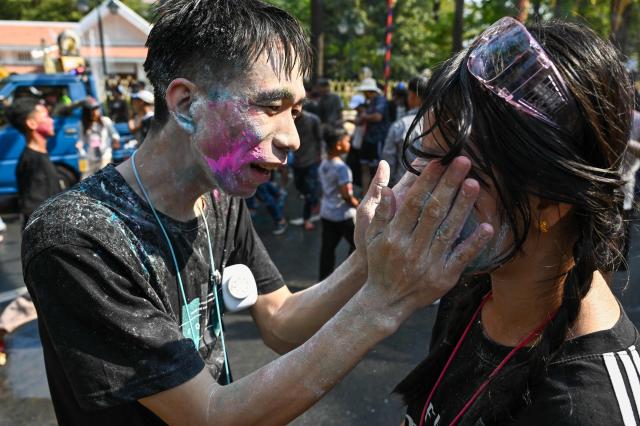 People play with powder during celebrations for the Khmer New Year, known as Nokor Sankranta, at Wat Phnom in Phnom Penh on April 14, 2026. (Photo by TANG CHHIN SOTHY / AFP)