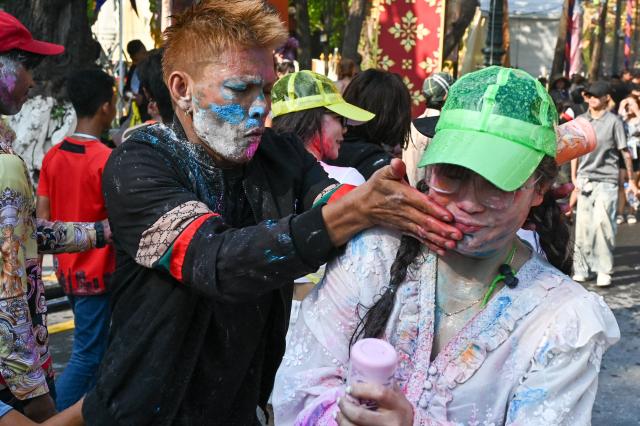 People play with powder during celebrations for the Khmer New Year, known as Nokor Sankranta, at Wat Phnom in Phnom Penh on April 14, 2026. (Photo by TANG CHHIN SOTHY / AFP)