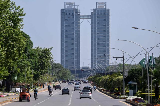 Motorists ride along a road on Islamabad’s Constitution Avenue on April 14, 2026. As the clock ticked down to US President Donald Trump's deadline to destroy Iran's civilisation last week, hope emerged from an unlikely corner, with Pakistan's prime minister first seeking -- and within hours securing -- a two-week ceasefire between the warring sides. (Photo by Farooq NAEEM / AFP)