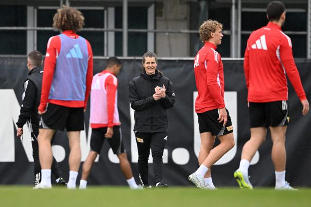 Union Berlin's new German head coach Marie-Louise Eta (C) speaks with players during a training session of German first division Bundesliga football club 1 FC Union Berlin in Berlin on April 14, 2026. Bundesliga club Union Berlin named Marie-Louise Eta as head coach, making her the first female manager of a men's team in a top-five European league, after former mentor Steffen Baumgart was sacked. The 34-year-old will take over for the remainder of the season. (Photo by RALF HIRSCHBERGER / AFP)
