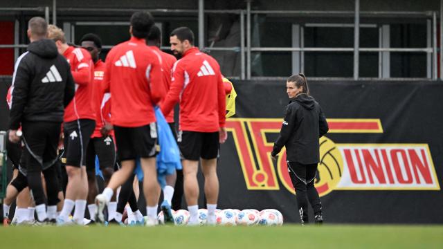 Union Berlin's new German head coach Marie-Louise Eta (R) looks towards her players during a training session of German first division Bundesliga football club 1 FC Union Berlin in Berlin on April 14, 2026. Bundesliga club Union Berlin named Marie-Louise Eta as head coach, making her the first female manager of a men's team in a top-five European league, after former mentor Steffen Baumgart was sacked. The 34-year-old will take over for the remainder of the season. (Photo by RALF HIRSCHBERGER / AFP)