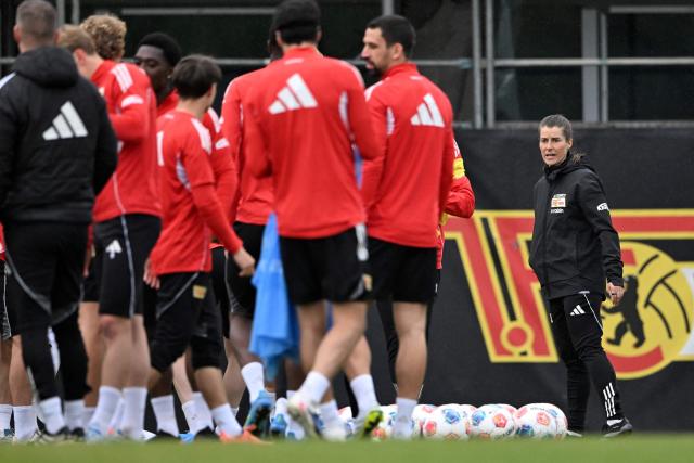Union Berlin's new German head coach Marie-Louise Eta (R) speaks with her players during a training session of German first division Bundesliga football club 1 FC Union Berlin in Berlin on April 14, 2026. Bundesliga club Union Berlin named Marie-Louise Eta as head coach, making her the first female manager of a men's team in a top-five European league, after former mentor Steffen Baumgart was sacked. The 34-year-old will take over for the remainder of the season. (Photo by RALF HIRSCHBERGER / AFP)
