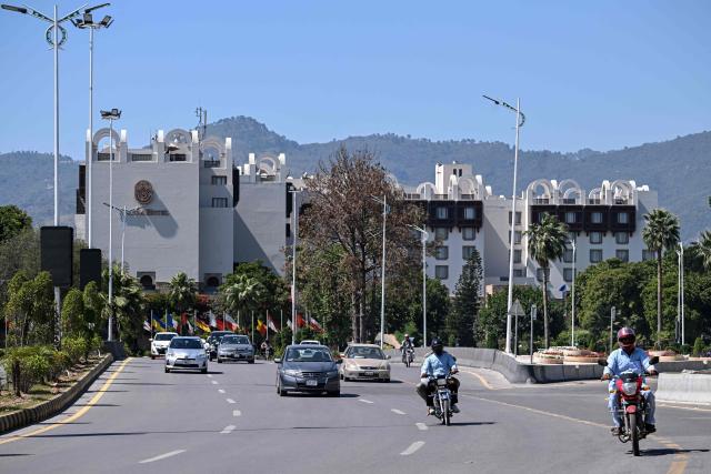 Motorists ride past Serena Hotel, the venue where Iran and the United States held peace talks earlier in Islamabad on April 14, 2026. As the clock ticked down to US President Donald Trump's deadline to destroy Iran's civilisation last week, hope emerged from an unlikely corner, with Pakistan's prime minister first seeking -- and within hours securing -- a two-week ceasefire between the warring sides. (Photo by Farooq NAEEM / AFP)
