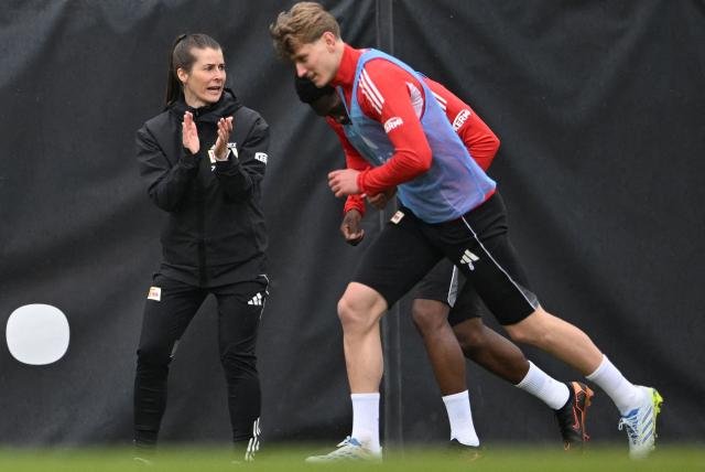 Union Berlin's new German head coach Marie-Louise Eta (L) watches her players during a training session of German first division Bundesliga football club 1 FC Union Berlin in Berlin on April 14, 2026. Bundesliga club Union Berlin named Marie-Louise Eta as head coach, making her the first female manager of a men's team in a top-five European league, after former mentor Steffen Baumgart was sacked. The 34-year-old will take over for the remainder of the season. (Photo by RALF HIRSCHBERGER / AFP)