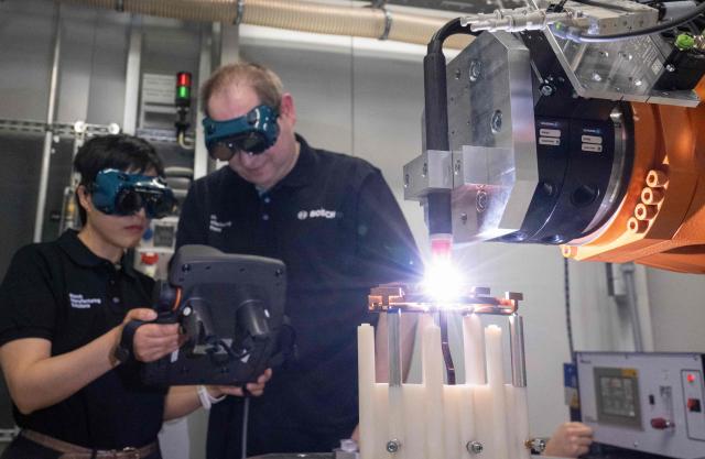 Employees of Bosch Manufacturing Solutions control copper welding in the eDrive Lab in Stuttgart, southern Germany, on April 14, 2026. The eDrive Lab optimizes the manufacturing steps for serial production of electric drives. Bosch will hold its annual press conference on April 16, 2026. (Photo by THOMAS KIENZLE / AFP)