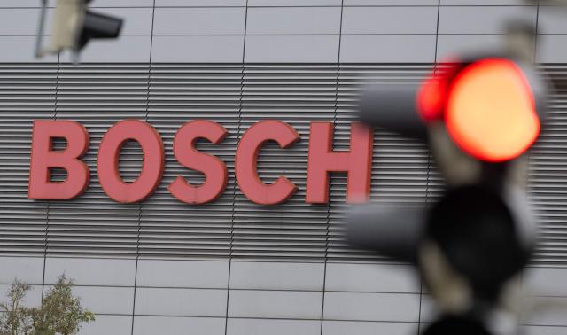 A red traffic light is seen next to the logo of German technology company Bosch in Stuttgart, southern Germany, on April 14, 2026. Bosch will hold its annual press conference on April 16, 2026. (Photo by THOMAS KIENZLE / AFP)