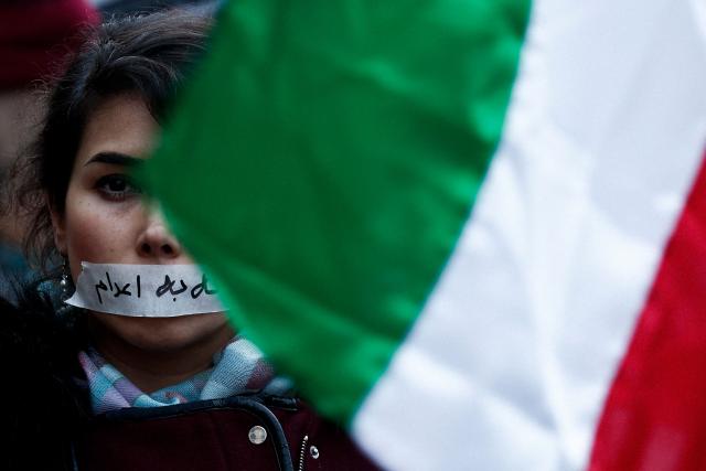 (FILES) A demonstrator wears a sticker over her mouth with the words "no execution" next to an Iranian flag, during a silent march denouncing the Iranian government's deadly crackdown on anti-government protesters in the Islamic Republic, in Paris on January 31, 2026. Iranian authorities have sentenced to death four more people, including a woman, over protests in January this year, several rights groups said on April 14, 2026. Iran has already hanged seven people in connection with the protests which activists say were put down in a crackdown that left thousands dead and tens of thousands arrested. (Photo by Sébastien DUPUY / AFP)