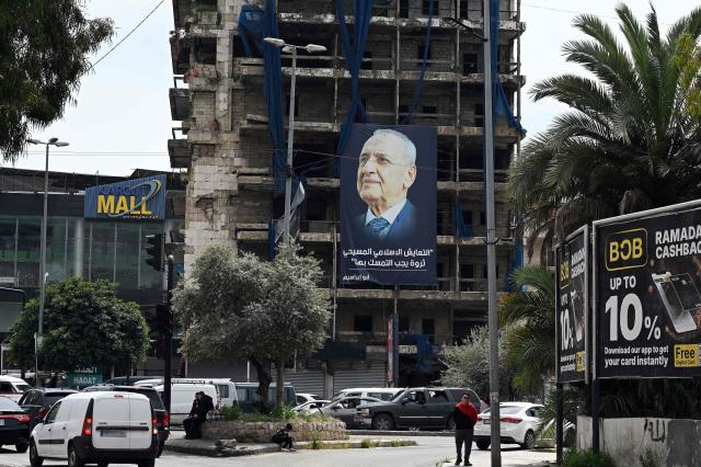A giant poster of Lebanese Parliament Speaker Nabih Berri under which reads "Coexistence between Muslims and Christians is a valuable treasure that must be preserved" hangs on building at the entrance of Beirut's southern suburbs Hadath neighbourhood on April 14, 2026. Israel said it was open to peace with Lebanon ahead of the first direct talks in decades between the neighbours on April 14, but that Hezbollah remained the "problem" blocking an agreement on ending fighting. (Photo by Joseph EID / AFP)