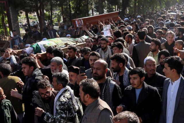 Mourners and relatives carry coffins to offer funeral prayers for victims killed in an attack by unidentified gunmen in Herat on April 14, 2026 following a shooting incident on April 11. The death toll from a shooting in western Afghanistan hit 11, the provincial authority said after gunmen targeted civilians at a picnic spot in Herat. (Photo by Mohsen KARIMI / AFP)