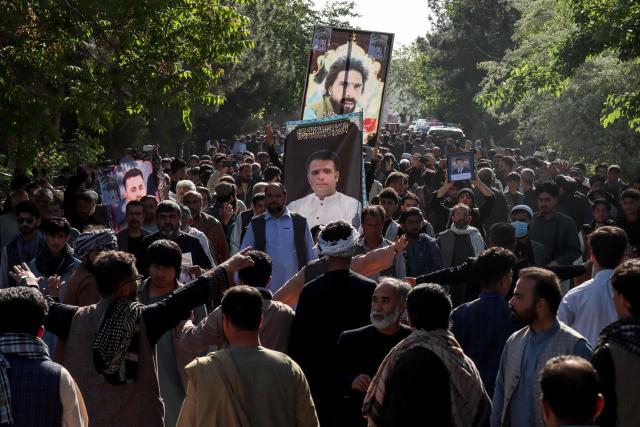 Mourners and relatives carry coffins to offer funeral prayers for victims killed in an attack by unidentified gunmen in Herat on April 14, 2026 following a shooting incident on April 11. The death toll from a shooting in western Afghanistan hit 11, the provincial authority said after gunmen targeted civilians at a picnic spot in Herat. (Photo by Mohsen KARIMI / AFP)