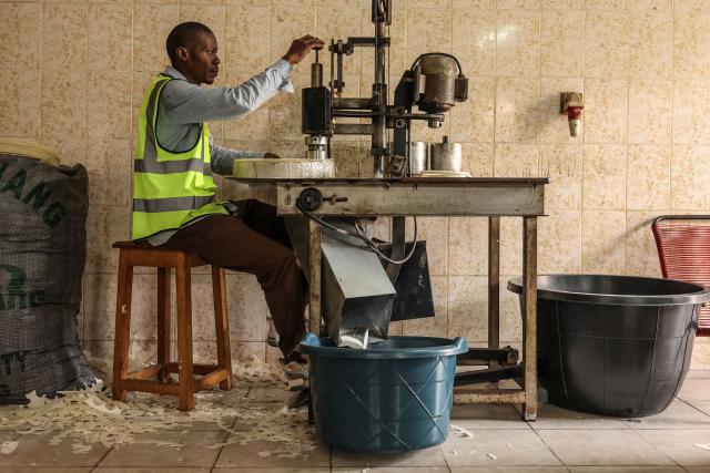 A worker cuts communion wafers on a machine at the nuns' monastery in Yaounde on April 14, 2026. (Photo by Daniel BELOUMOU OLOMO / AFP)