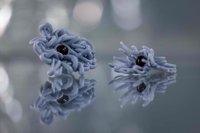 This picture presents pieces of artistic jewelery made of natural Baltic amber, designed with use of Virtual Reality and created with use of 3d printing techinc by Martyna Golinska - a student of Experimental Design Stuio on Academy of Fine Arts in Gdansk, Poland on March 10, 2026. Long coveted for its golden color, scientific value, and alleged healing properites, amber is now coming into the hand of young Polish jewelers, bringing the ancient resin into modern times. Together with drills, sanders, blasters, and power saws which look like they belong to a bygone era, virtual reality stations are used to combine earlier tools with state-of-the-art technology at the Academy of Fine Arts in Gdansk, a city on Poland's Baltic Coast known as amber's global capital. (Photo by Wojtek RADWANSKI / AFP)