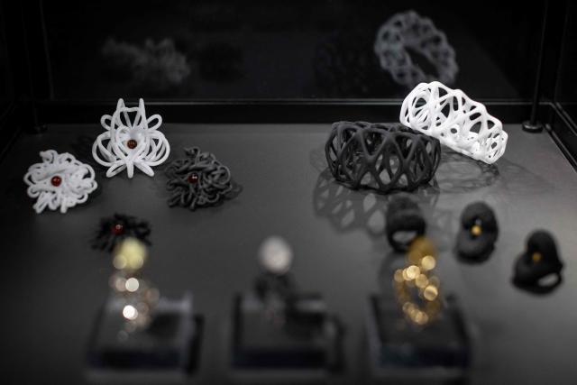 This picture taken at the exhibion of Amber Museum in Gdansk presents pieces of artistic jewellery made of natural Baltic amber, designed with use of Virtual Reality and created with use of 3d printing techinc by Martyna Golinska - a student of Experimental Design Stuio of Academy of Fine Arts in Gdansk, Poland on March 10, 2026. Long coveted for its golden color, scientific value and alleged healing properties, amber is now coming into the hand of young Polish jewelers, bringing the ancient resin into modern times. Together with drills, sanders, blasters, and power saws which look like they belong to a bygone era, virtual reality stations are used to combine earlier tools with state-of-the-art technology at the Academy of Fine Arts in Gdansk, a city on Poland's Baltic Coast known as amber's global capital. (Photo by Wojtek RADWANSKI / AFP)