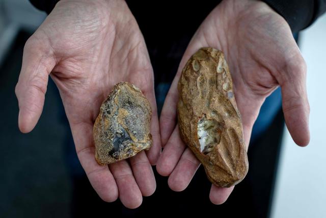 Michal Kosior, gemologist, amber specialist and founder of "Amber Expert", presents a piece of natural Baltic amber (L) and a plastic fake (R) in his laboratory in Gdansk, northern Poland, on March 11, 2026. Formed some 40 million years ago from conifer resins, amber often contains air bubbles, plant fragments or insects trapped before fossilisation, granting each piece a unique "fingerprint". In Gdansk itself, workshops, shops and stalls dedicated to amber abound on every corner of the historic centre, each attracting flocks of tourists. (Photo by Wojtek RADWANSKI / AFP)
