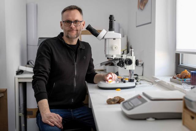 Michal Kosior, gemologist, amber specialist and founder of "Amber Expert", poses for photos in his laboratory in Gdansk, northern Poland, on March 11, 2026. Formed some 40 million years ago from conifer resins, amber often contains air bubbles, plant fragments or insects trapped before fossilisation, granting each piece a unique "fingerprint". In Gdansk itself, workshops, shops and stalls dedicated to amber abound on every corner of the historic centre, each attracting flocks of tourists. (Photo by Wojtek RADWANSKI / AFP)