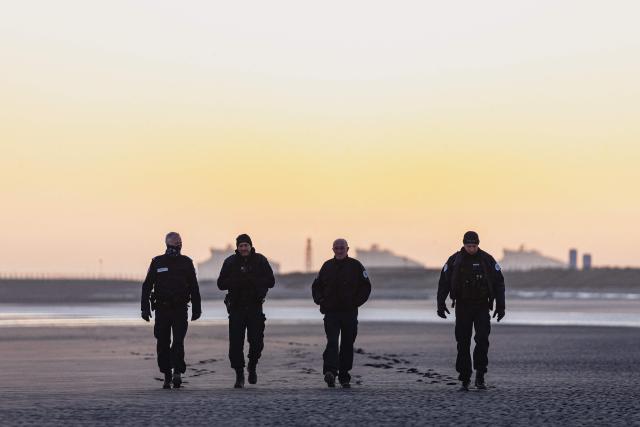 French police officers patrol the Gravlelines beach at sunrise in a bid to prevent migrants from crossing the English Channel, in Gravelines, northern France on April 14, 2026. (Photo by Sameer Al-DOUMY / AFP)