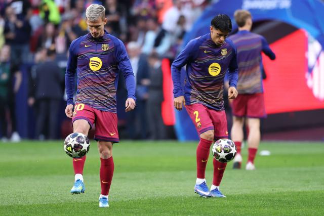 Barcelona's Spanish midfielder #20 Daniel Olmo (L) and Barcelona's Portuguese defender #02 Joao Cancelo warm up before the UEFA Champions League quarter final second leg football match between Club Atletico de Madrid and FC Barcelona at Metropolitano Stadium in Madrid on April 14, 2026. (Photo by Thomas COEX / AFP)