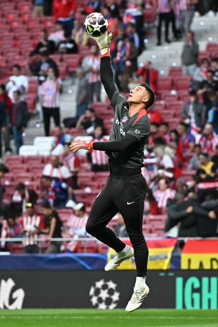 Atletico Madrid's Argentine goalkeeper #01 Juan Musso jumps for the ball during the warm up before the UEFA Champions League quarter final second leg football match between Club Atletico de Madrid and FC Barcelona at Metropolitano Stadium in Madrid on April 14, 2026. (Photo by Javier SORIANO / AFP)