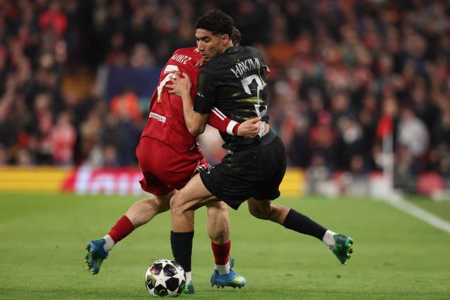 Liverpool's German midfielder #07 Florian Wirtz (L) vies with Paris Saint-Germain's Moroccan defender #02 Achraf Hakimi (R) during the UEFA Champions League quarter final, second-leg football match between Liverpool and Paris Saint-Germain at Anfield in Liverpool, north west England on April 14, 2026. (Photo by FRANCK FIFE / AFP)