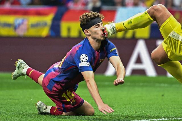 Barcelona's Spanish midfielder #16 Fermin Lopez (L) collides with Atletico Madrid's Argentine goalkeeper #01 Juan Musso during the UEFA Champions League quarter final second leg football match between Club Atletico de Madrid and FC Barcelona at Metropolitano Stadium in Madrid on April 14, 2026. (Photo by Javier SORIANO / AFP)