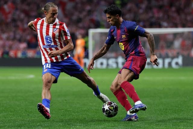 Atletico Madrid's Spanish midfielder #14 Marcos Llorente fights for the ball with Barcelona's Portuguese defender #02 Joao Cancelo during the UEFA Champions League quarter final second leg football match between Club Atletico de Madrid and FC Barcelona at Metropolitano Stadium in Madrid on April 14, 2026. (Photo by Thomas COEX / AFP)