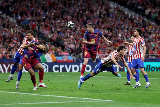 Barcelona's Polish forward #09 Robert Lewandowski (C) heads the ball during the UEFA Champions League quarter final second leg football match between Club Atletico de Madrid and FC Barcelona at Metropolitano Stadium in Madrid on April 14, 2026. (Photo by Thomas COEX / AFP)