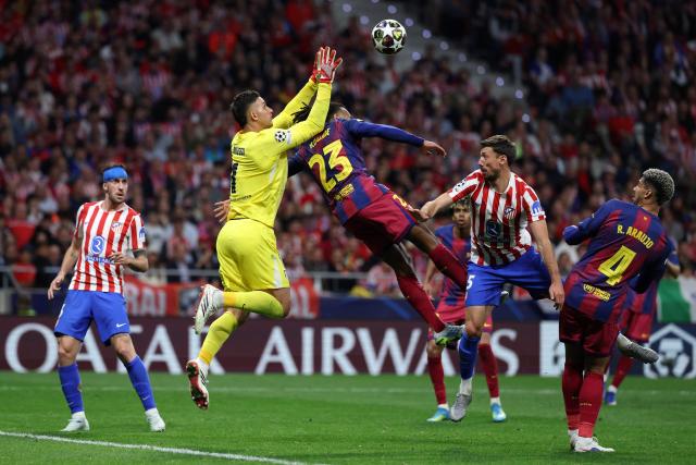 Barcelona's French defender #23 Jules Kounde challenges Atletico Madrid's Argentine goalkeeper #01 Juan Musso during the UEFA Champions League quarter final second leg football match between Club Atletico de Madrid and FC Barcelona at Metropolitano Stadium in Madrid on April 14, 2026. (Photo by Thomas COEX / AFP)