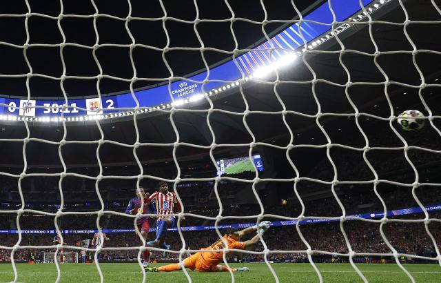 Atletico Madrid's English forward #22 Ademola Lookman scores his team's first goal in spite of Barcelona's Spanish goalkeeper #13 Joan Garcia during the UEFA Champions League quarter final second leg football match between Club Atletico de Madrid and FC Barcelona at Metropolitano Stadium in Madrid on April 14, 2026. (Photo by Oscar DEL POZO / AFP)