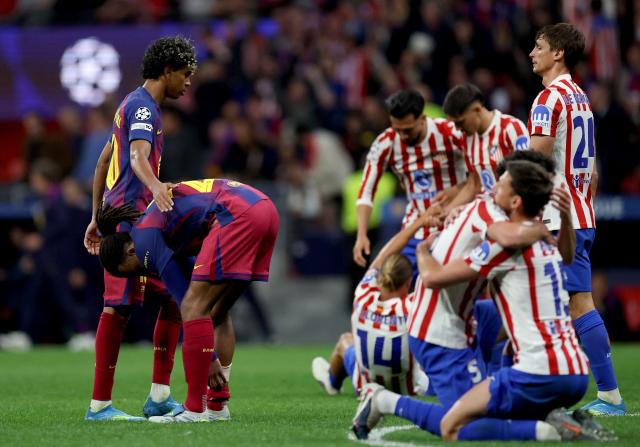Barcelona's Spanish forward #10 Lamine Yamal (L) looks dejected as Atletico Madrid's players celebrate at the end of the UEFA Champions League quarter final second leg football match between Club Atletico de Madrid and FC Barcelona at Metropolitano Stadium in Madrid on April 14, 2026. Atletico Madrid reaches the Champions League semi-finals. (Photo by Oscar DEL POZO / AFP)