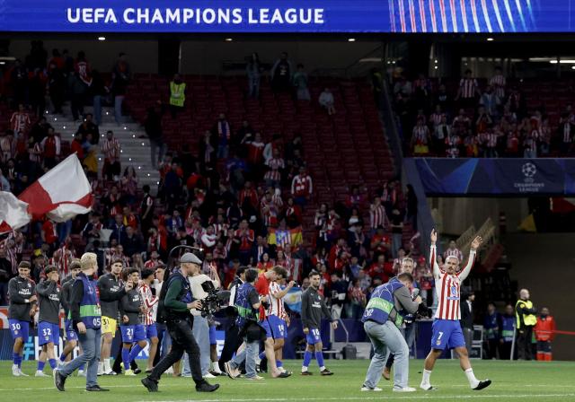 Atletico Madrid's French forward #07 Antoine Griezmann (R) and teammtes celebrate at the end of the UEFA Champions League quarter final second leg football match between Club Atletico de Madrid and FC Barcelona at Metropolitano Stadium in Madrid on April 14, 2026. Atletico Madrid reaches the Champions League semi-finals. (Photo by Oscar DEL POZO / AFP)