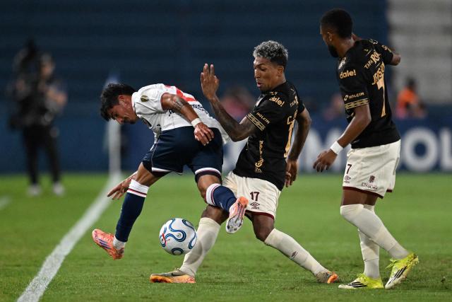 Nacional's midfielder #23 Lucas Rodriguez and Tolima's defender #17 Cristian Arrieta fight for the ball next to Tolima's forward #07 Jersson Gonzalez during the Copa Libertadores group stage football match between Uruguay's Nacional and Colombia's Deportes Tolima at the Gran Parque Central stadium in Montevideo on April 14, 2026. (Photo by Eitan ABRAMOVICH / AFP)