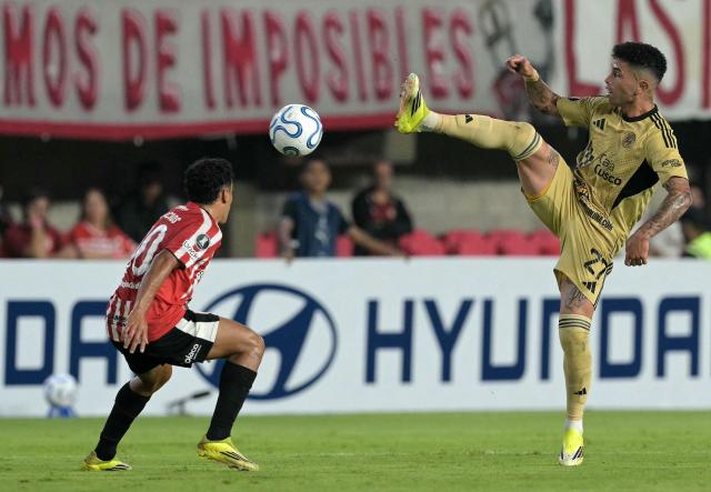 Cusco's Argentine midfielder #27 Gabriel Carabajal (R) and Estudiantes' Uruguayan forward #10 Tiago Palacios fight for the ball during the Copa Libertadores group stage football match between Argentina's Estudiantes de La Plata and Peru's Cusco FC at the Jorge Luis Hirschi stadium in La Plata, Buenos Aires province, Argentina, on April 14, 2026. (Photo by JUAN MABROMATA / AFP)