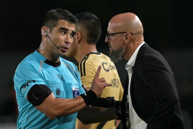 Chilean referee Jose Cabero talks to Cusco's Uruguayan head coach Alejandro Orfila during the Copa Libertadores group stage football match between Argentina's Estudiantes de La Plata and Peru's Cusco FC at Jorge Luis Hirschi stadium in La Plata, Buenos Aires province, Argentina on April 14, 2026. (Photo by JUAN MABROMATA / AFP)