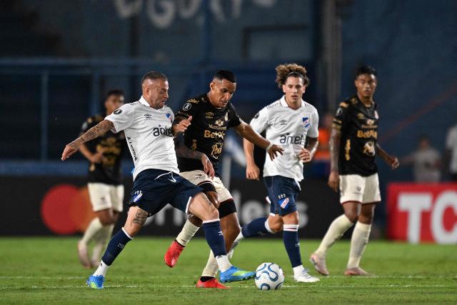 Nacional's midfielder #07 Nicolas Lopez and Tolima's midfielder #80 Bryan Rovira fight for the ball during the Copa Libertadores group stage football match between Uruguay's Nacional and Colombia's Deportes Tolima at the Gran Parque Central stadium in Montevideo on April 14, 2026. (Photo by Eitan ABRAMOVICH / AFP)