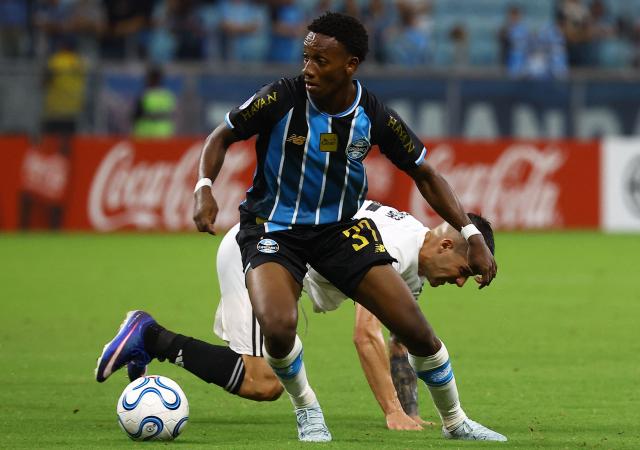 Gremio's midfielder #37 Gabriel Mec and Deportivo Riestra's forward #35 Angel Stringa (back) fight for the ball during the Copa Sudamericana group stage football match between Brazil's Gremio and Argentina's Deportivo Riestra at the Arena do Gremio stadium in Porto Alegre, state of Rio Grande do Sul, Brazil, on April 14, 2026. (Photo by SILVIO AVILA / AFP)