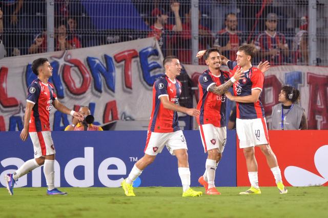 Cerro Porteno's Argentine forward #27 Jonathan Torres celebrates with teammates Argentine defender #03 Matias Perez and midfielder Mateo Klimowicz after scoring the opening goal during the Copa Libertadores group stage football match between Paraguay's Cerro Porteno and Colombia's Junior at the La Nueva Olla stadium in Asuncion on April 14, 2026. (Photo by Daniel Duarte / AFP)