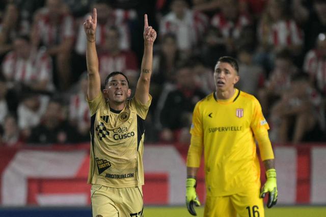 Cusco's Argentine midfielder #22 Lucas Colitto celebrates scoring his team's first goal as Estudiantes' Uruguayan goalkeeper #16 Fernando Muslera looks on during the Copa Libertadores group stage football match between Argentina's Estudiantes de La Plata and Peru's Cusco FC at the Jorge Luis Hirschi stadium in La Plata, Buenos Aires province, Argentina, on April 14, 2026. (Photo by JUAN MABROMATA / AFP)