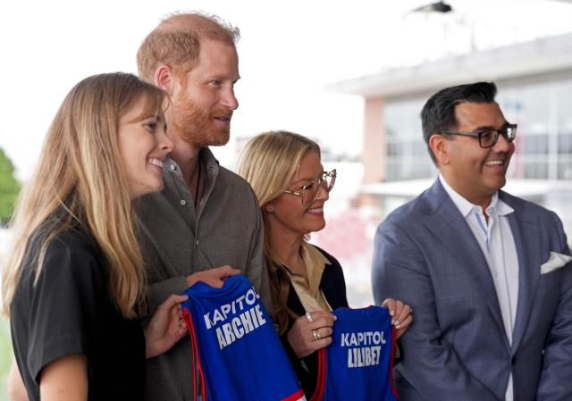 Britain's Prince Harry (2/L), Duke of Sussex, is presented with Western Bulldogs Archie and Lilibet jerseys during a visit to a Movember event at Whitten Oval in Melbourne on April 15, 2026. (Photo by Jonathan Brady / POOL / AFP)
