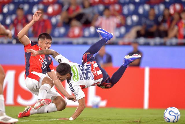 Cerro Porteno's Argentine defender Matias Perez (L) and Junior's forward #88 Bryan Castrillon fight for the ball during the Copa Libertadores group stage football match between Paraguay's Cerro Porteno and Colombia's Junior at the La Nueva Olla stadium in Asuncion on April 14, 2026. (Photo by Daniel Duarte / AFP)