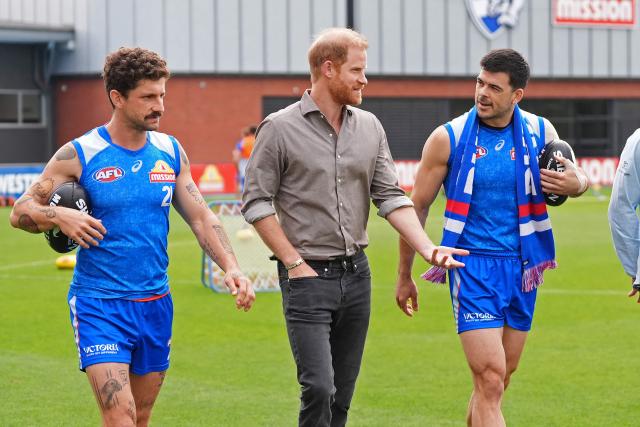 Britain's Prince Harry, Duke of Sussex (C) meets with Western Bulldogs Australian Football League (AFL) players Tom Liberatore (L) and Matthew Kennedy (R) during a visit to a Movember event at Whitten Oval in Melbourne on April 15, 2026. (Photo by Jonathan Brady / POOL / AFP)