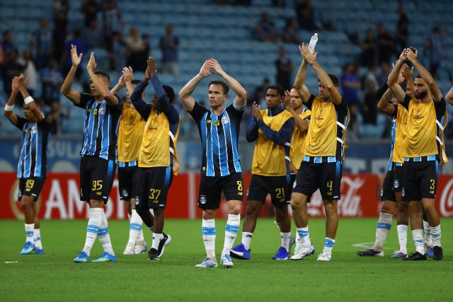 Gremio's players celebrate at the end of the Copa Sudamericana group stage football match between Brazil's Gremio and Argentina's Deportivo Riestra at the Arena do Gremio stadium in Porto Alegre, state of Rio Grande do Sul, Brazil, on April 14, 2026. (Photo by SILVIO AVILA / AFP)