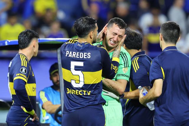 Boca Juniors' goalkeeper #01 Agustin Marchesin cries after being injured while being comforted by Boca Juniors' midfielder #05 Leandro Paredes during the Copa Libertadores group stage football match between Argentina's Boca Juniors and Ecuador's Barcelona at La Bombonera stadium in Buenos Aires on April 14, 2026. (Photo by ALEJANDRO PAGNI / AFP)