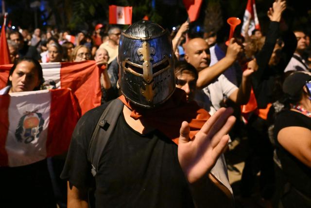 A demonstrator wearing a medieval helmet gestures as he takes part in a protest over alleged fraud following the results of the presidential election in front of the National Jury of Elections (JNE) headquarters in Lima on April 14, 2026. Ultra-conservative candidate Rafael Lopez Aliaga, who is vying for a spot in the runoff of Peru’s presidential election, called on election authorities on April 14 to declare the election “null and void” due to unproven irregularities in the process. (Photo by Luis ROBAYO / AFP)