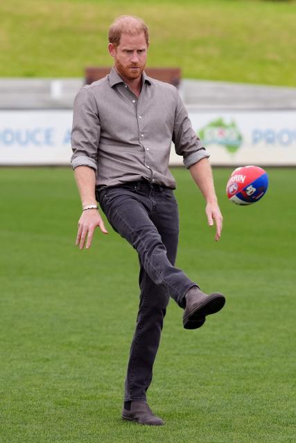 Britain's Prince Harry, Duke of Sussex (C), kicks a ball during a Western Bulldogs Australian rules football session during a visit to a Movember event at Whitten Oval in Melbourne on April 15, 2026. (Photo by Jonathan Brady / POOL / AFP)