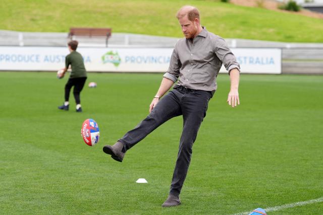 Britain's Prince Harry, Duke of Sussex (C), kicks a ball during a Western Bulldogs Australian rules football session during a visit to a Movember event at Whitten Oval in Melbourne on April 15, 2026. (Photo by Jonathan Brady / POOL / AFP)